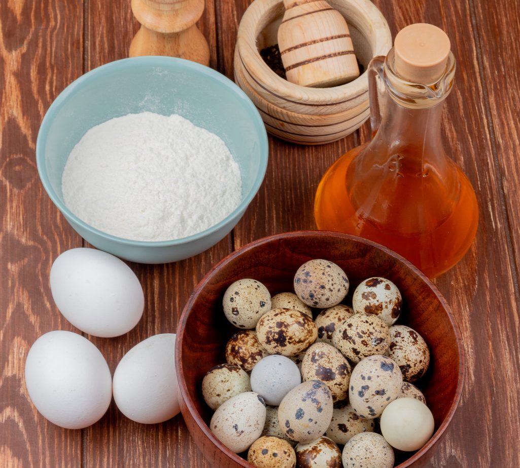 top view of quail eggs on a wooden bowl with flour on a blue bowl with apple vinegar with white chicken eggs on a wooden background SSUCv3H4sIAAAAAAAACpyRwW7DIAyG75P2DhHnRkpLuix9lWoHB5wGlUIFZNNU9d1nIFScd8Of7d/+zeP9rWnYBF4JdmoeMaJYab364CAoawh3u407NBJdTVCqYJ0CXcMJglgM3JCgWbWO+JmSzAcIq0cfh21IQMALaWT4ksgbnXPclERKUgelGNtVzK9TYgVl8X915sdXcQMXNOI3LVwZcagRspFzLmXXn4DuVluDVSpbufq2AnQs4JXS3SmhzKVqs2FJVy5twq4muLjCa3Omrb3DpOOJZ9LEwhfwnspl4dUgQX9qb9UcY0MysKkyST8Rwz0/9F0/7D/4OPTHIx/2W0H+vUWRTlqnCFEsrkrW1lXcgKH4nDscxxZHHNoeJ95OfOTtfDgeetFBJ4eZDv/8AwAA//8DABSnZzaHAgAA